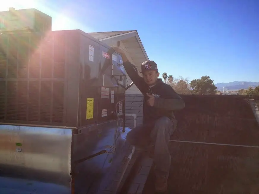 HVAC technician performing AC Tune-Up on a rooftop unit in McSwain